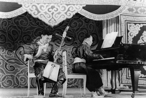 Mongolian musician dzhamyan performs a piece by schumann on a two stringed folk instrument called a marinkura (horse head fiddle), moscow, ussr, september 1947.