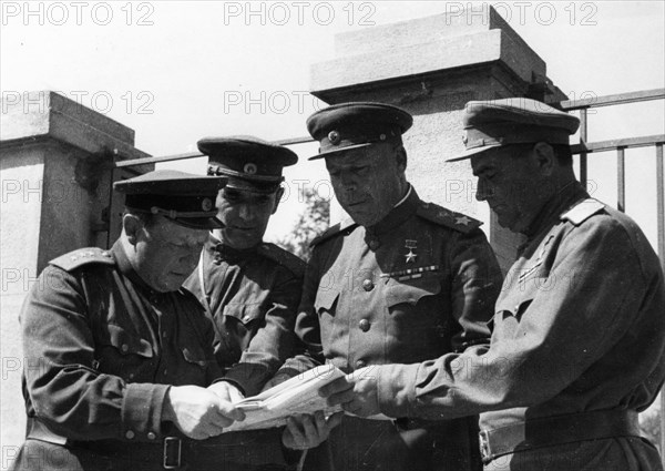 Marshal timoshenko, representative of the headquarters of the supreme command of the red army (second from right), explaining a new combat assignment to colonel-general kravchenko (right) for his tank battalion.