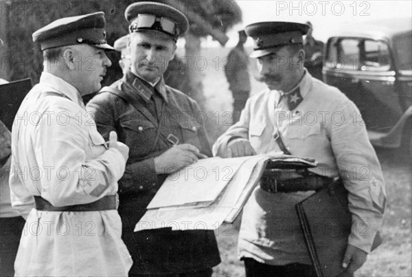 Peoples' commissar of defense, marshall kliment voroshilov, division commander vasily sokolovsky, and marshall semyon budyonny looking over a map during tactical exercises in the moscow military district, september 1938.