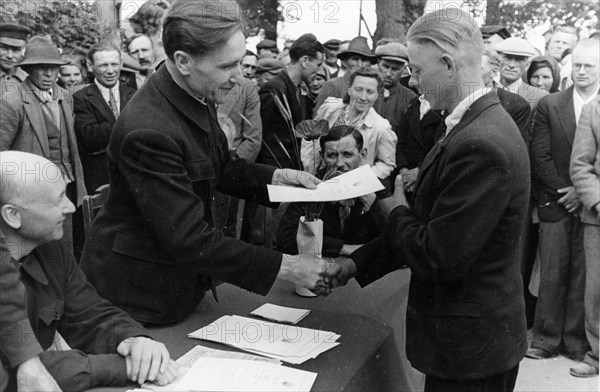 Latvian peasant, j, karklin receiving a deed entitling him to free and permanent holdings of land, july 1945.