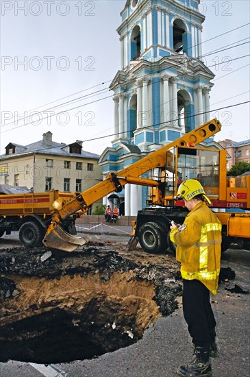 A digger-spas worker by a pit of 150 square meters and 3 meters deep that appeared under yauzsky street downtown moscow because of a cave-in, moscow, russia, august 4, 2005.