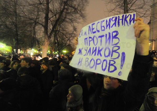 Moscow, russia, december 5, 2011, a demonstrator holds a banner reading 'gay men and lesbians are against swindlers and thieves' during an opposition protest in central moscow against alleged vote-rigging in the december 4 parliamentary election.