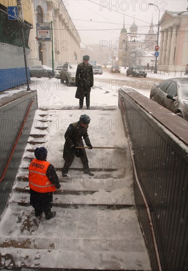 Moscow, russia, january 25, 2007, soldier shoveling snow from steps to a pedestrian underpass off red square during a winter snowstorm.