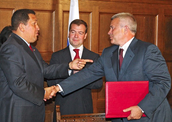 Moscow region, russia, july 22, russian president dmitry medvedev (c) looks on as venezuela's president hugo chavez (l) shakes hands with vagit alekperov, president of lukoil, russian oil company, at an agreement signing ceremony between russia and venezuela at the meindorf residence.