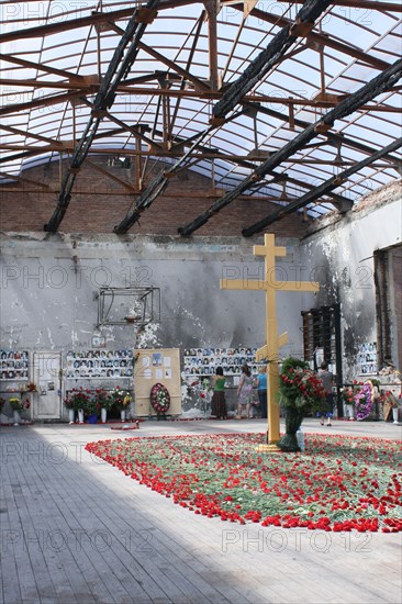 North ossetia, russia, september 3, 2008, christian orthodox cross erected in the center of the devastated former school no1 gym, the scene of the 2004 beslan school siege, mourners bring red carnations to the scene as russia commemorates the 4th anniversary of the tragedy.