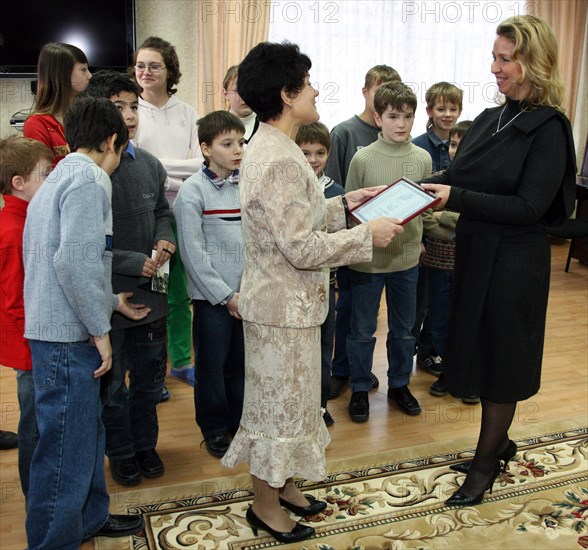 St petersburg, russia, november 4, 2008, svetlana medvedeva (r) hands over the $19000 (500 000 rubles) grant to school principal lyudmila borovikova (c) during a visit of russia's first lady to an orphanage/boarding school (number 13).