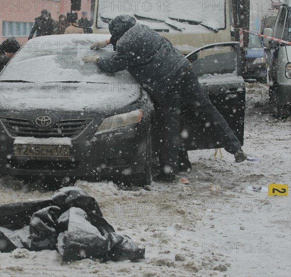 Moscow, russia, december 29, 2008, the body of tax crimes police officer roman maslov lies near his toyota car in which he was shot dead in the yard of his house.