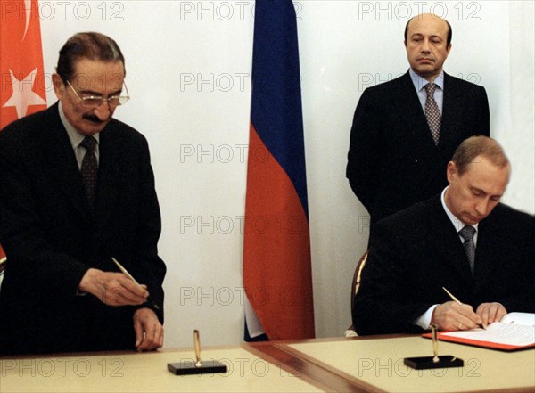 Russian prime minister vladimir putin and his turkish counterpart bulent ecevit signing agreements on scientific, technical, and military co-operation while russian foreign minister igor ivanov looks on during the signing ceremony at the russo-turkish intergovernmental negotiations, the two countries' premiers initiated a declaration on the struggle against terrorism, november 5, 1999, moscow, russia.