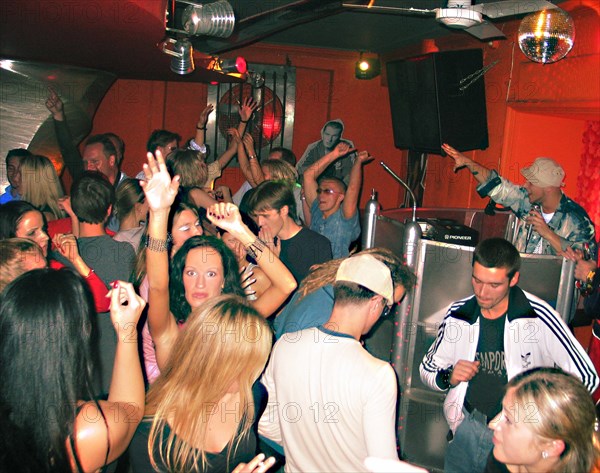 Young latvians dancing at nautilus a popular night club in riga's old city, latvia, 2003.