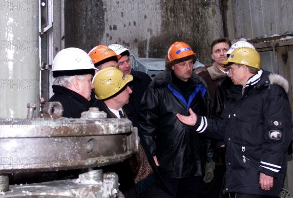 Surgut,russia, march 3 2000, acting president vladimir putin (right) wearing a helmet talks to oil workers during his visit to a drilling station near the western siberian city of surgut