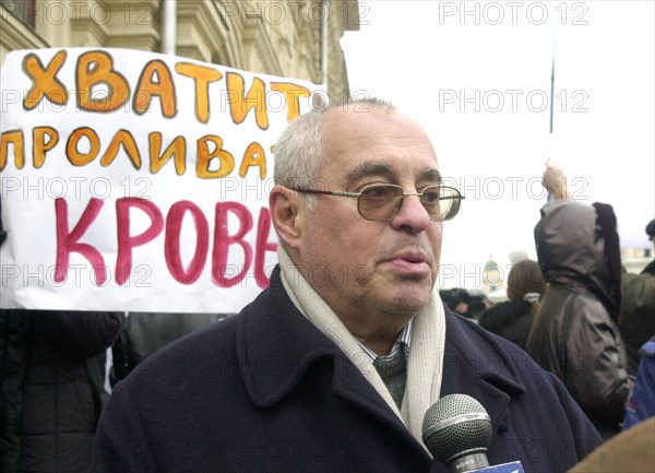 Moscow, russia, october 25 2002: theater producer mark rozovsky pictured (against the background of the slogan 'stop bloodshed !') speaking at the meeting held near the st basil cathedral organized by relatives of those taken hostage by a group of terrorists in the palace of culture of the ball-bearing plant.