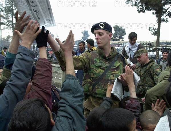 Kabul, afghanistan 2/03, afghani children with a soldier of the international peacekeeping force.