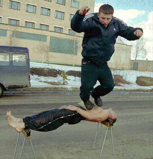 Physical endurance; firefighters, bryansk, russia, march 27 2003, captain of the russian interior ministry forces, guard commander of a bryansk fighfighters' unit mikhail karpeshin (bottom) demonstrates his unique physical abilities, lying on two supports and holding a man on his chest, karpeshin formerly worked as circus performer, demonstrating his amazing skills, (photo itar-tass/vladimir gorovykh).