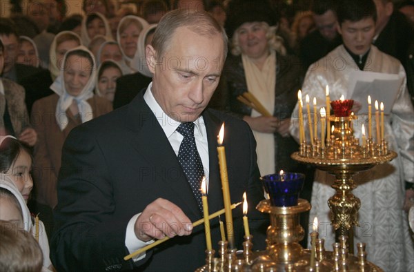 Russian president vladimir putin lights a candle during russian orthodox christmas celebrations on the eve of the holiday friday in a cathedral in the siberian city of yakutsk, orthodox christians use the old julian calendar and mark christmas on jan, 7, 2006.