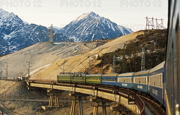 A passenger train on the devil's bridge on the baikal-amur railway (a leg of the trans-siberian railroad) in buryatia, siberia, russia.