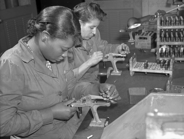 Production. Aircraft engines. Negro women with no previous industrial experience are reconditioning used spark plugs in a large Midwest airplane plant.