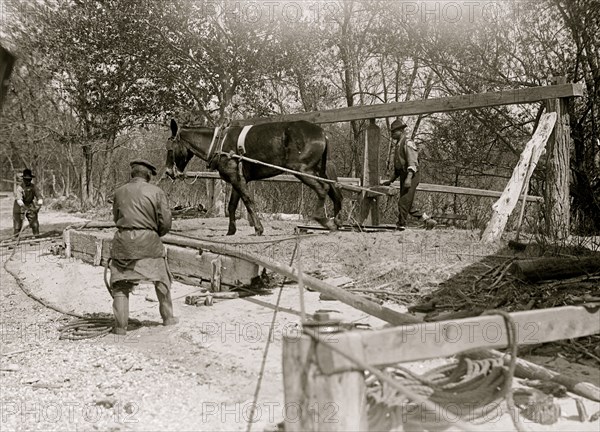 African American drilling a well with a horse on a turnstile