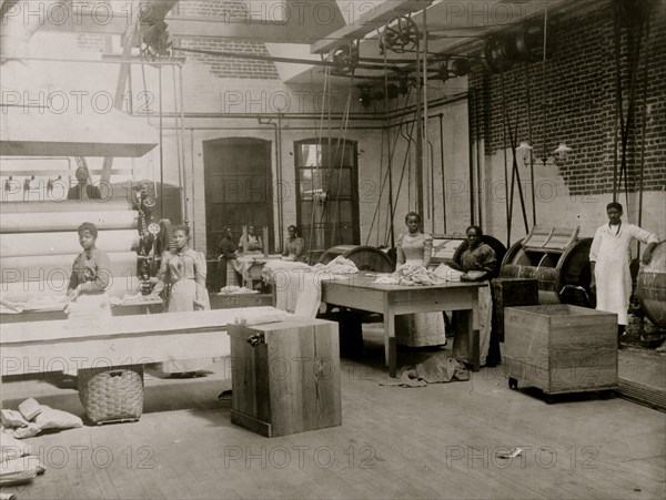 African American women and men posed by machinery, Lexington Laundry