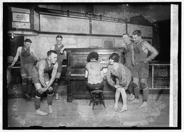 1926 -  Miss Vivian Marinelli giving Charleston dancing lessons to basketball players of the Palace Club, the Washington, D.C., entry in the American basketball league. Left to right: Kearns, Manager Kennedy, Conway, woman playing piano, Miss Marinelli, Grody, and Saunders.