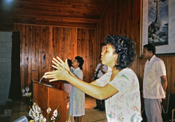 (R) Woman singing during a worship service in a small church in Honduras circa 1987.