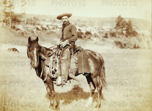 Photograph shows side view of a cowboy on a horse, looking towards the camera 1888.