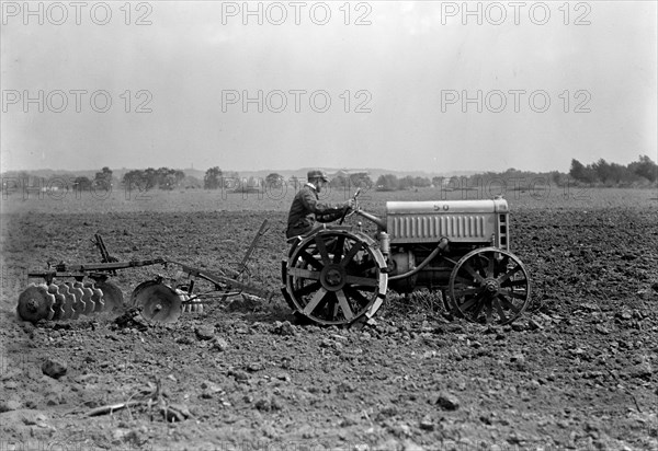 Farmer driving Ford Tractor in field circa 1917.