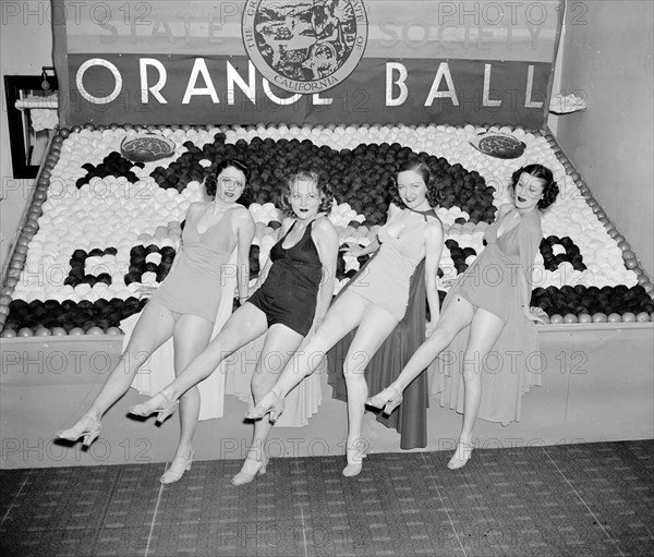 Women posing with California orange week festival ball display circa 1938.