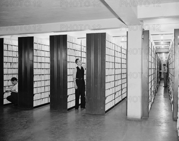 United States Patent office workers looking through collection of over 2,000,000  patents circa 1940 .