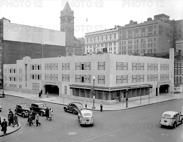 Street scene with buses, cars and pedestrians outside Star Parking Plaza in Washington D.C. circa 1940 .