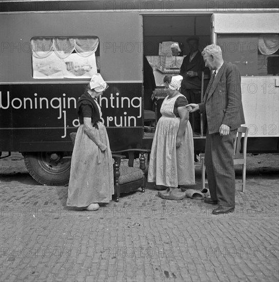 Woman looking at furniture from the Furniture trolley - Walcheren, Zeeland Date October 23, 1947.