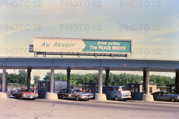 (R) New York 1975 - U.S. Canada border crossing - cars leaving the country circa 1975.