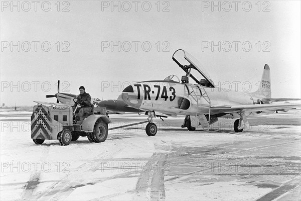 A T-33 aircraft is towed on the flight line