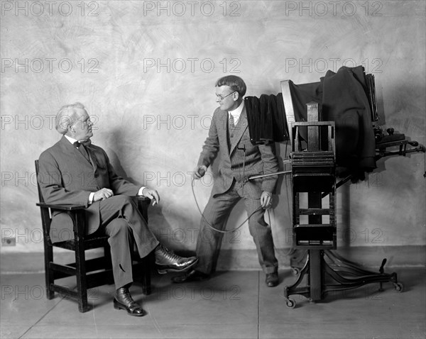 Cliff Berryman being posed for a portrait at the Harris & Ewing Studio