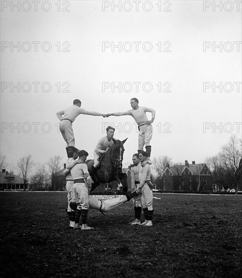 Horse jumping through group of men