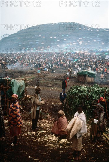 Group of refugees with the refugee camp in the background