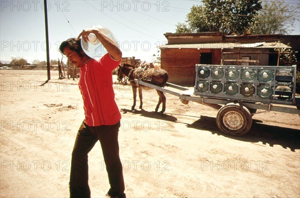 A vendor delivers bottled water from a nearby spring to a home in Mexicali