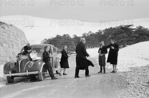 Photographic party stops for a cold snowy lunch ca. 1946