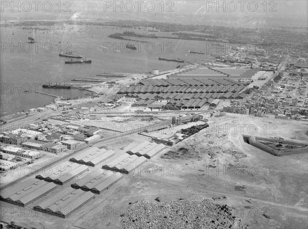 Aerial view of Alexandria Harbour in Egypt, warehouses and railroad station ca. 1932