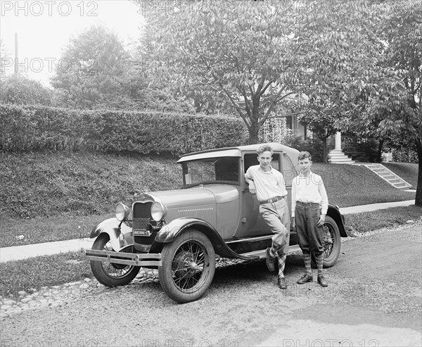 Boys standing next to automobile. ca.  between 1910 and 1920