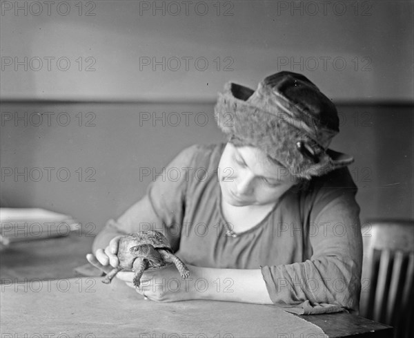 Woman holding a turtle ca.  between 1918 and 1920