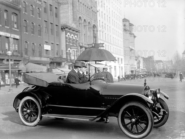 Early 1900s automobile observing the stop and go signs on a Washington D.C. Street