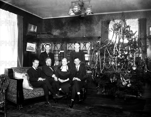 Family photo next to a Christmas tree ca. 1919