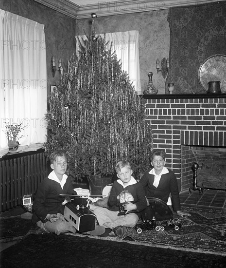 These happy boys grouped about their Christmas tree are George