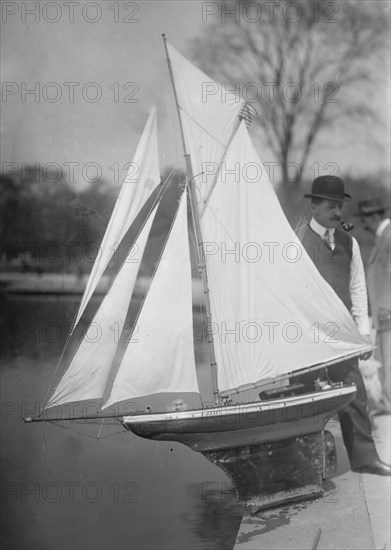 Man with a model yacht (gaff cutter) at Conservatory Lake, Central Park, New York City ca. 1910-1915