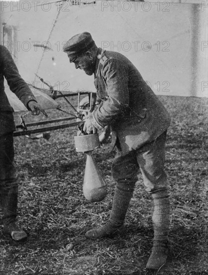 German soldier attaching a bomb to an airplane during World War I ca. 1915