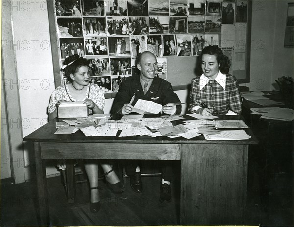 Answering letters from grateful Berlin children who have received some of the 'candychutes' dropped by First Lt Gail S Halvorsen, Garland, Utah, originator of Project Little Vittles, is a sizeable job. Halvorsen is shown here with his two assistants, Miss Gisela Hering (left), translator, and Mrs Margaret Preston, secretary, at work at the Rhein