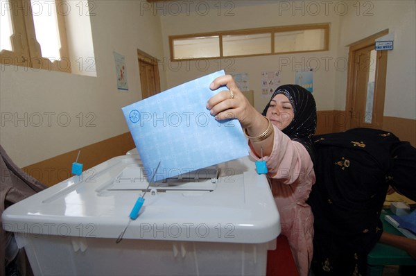 An Afghan woman puts her parliament ballot