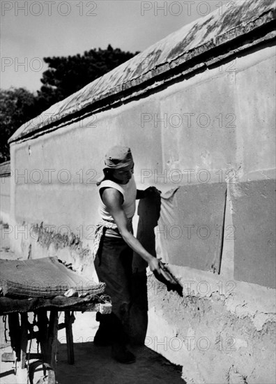 Paper Recycling. Worker Spreads Sheets Of Paper On The Wall To Make Them Dry. China 1940-50