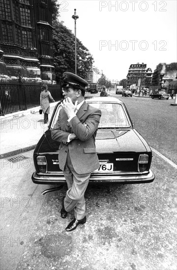 Driver attending near his car, london, uk, 70's