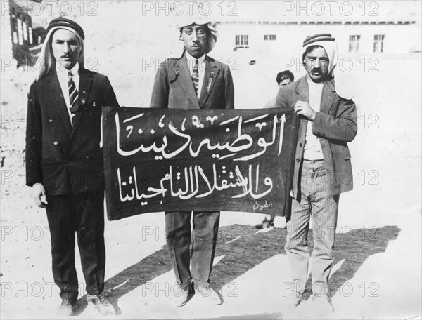 Three Arabs from Palestine walk through Jerusalem demanding their complete freedom on a banner